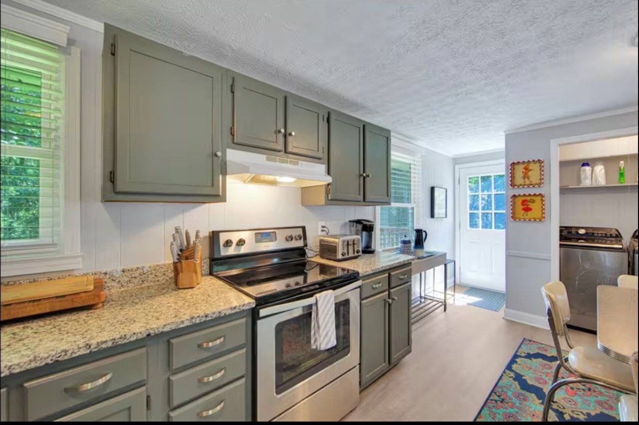 Kitchen with sage cabinets and granite counters