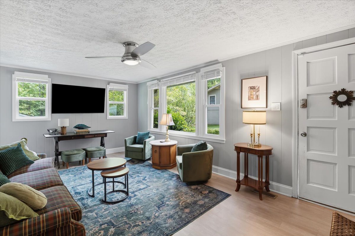 Living room with TV, sofa, and armchairs